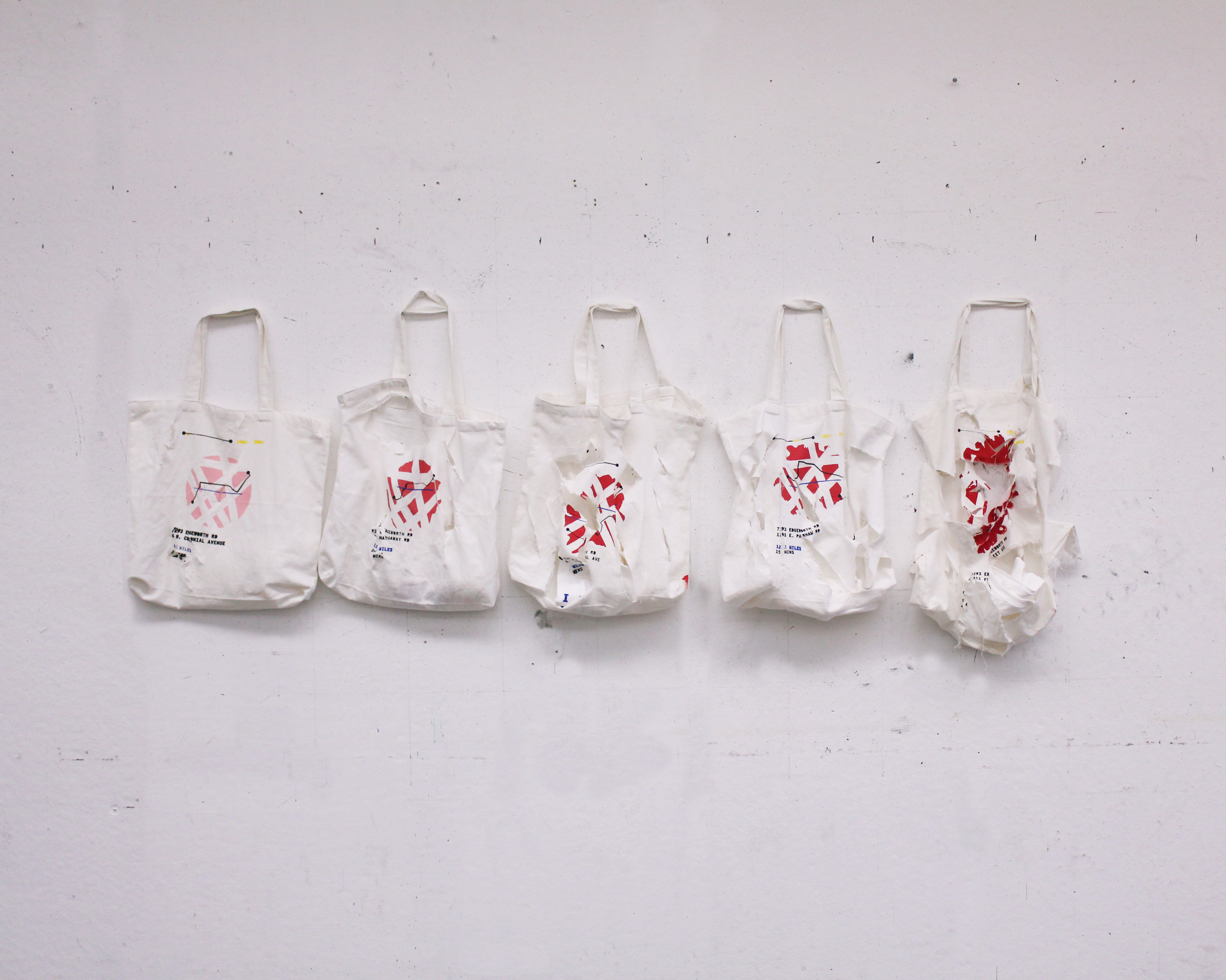 five tote bags hanging on a white wall, gradually from left to right becoming more visibly distressed. in the middle of the bag, a pink circle that gradually mutates and turns red